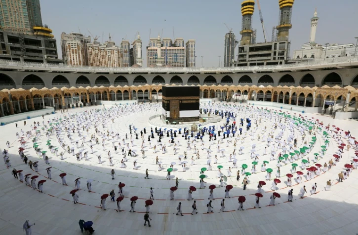 Des pèlerins restent à distance les uns des autres en faisant le tour traditionnel de la Kaaba, à La Mecque, le 29 juillet 2020