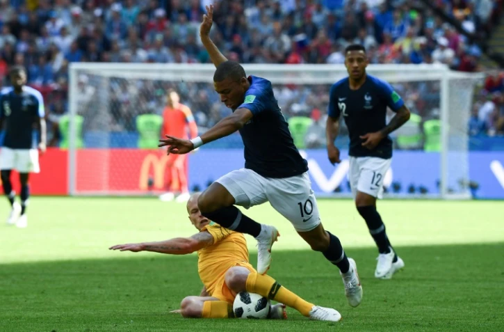 L'attaquant français Kylian Mbappé taclé par l'Australien Aaron Mooy lors du Mondial le 16 juin 2018 à Kazan