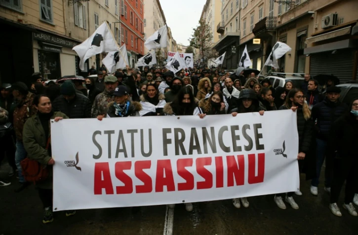 Des manifestants corses portent une banderole sur laquelle est écrit "Etat français assassin", lors de la manifestation à Bastia, le 13 mars 2022