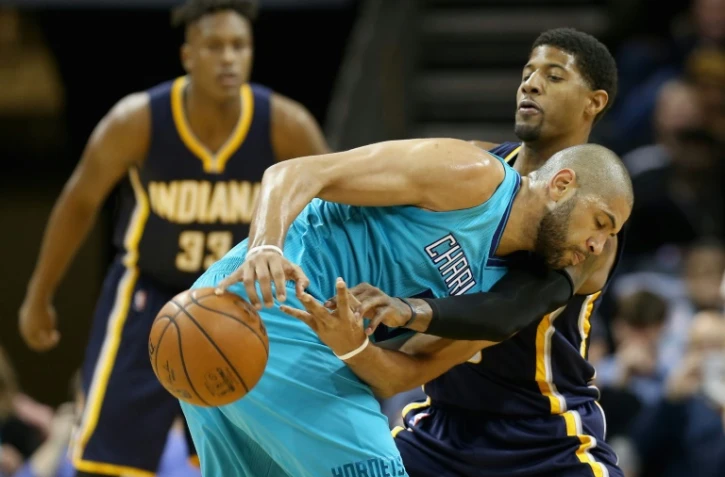 Le joueur de Charlotte Nicolas Batum (c) face Ă deux basketeurs d'Indiana, Ă Charlotte le 4 mars 2016