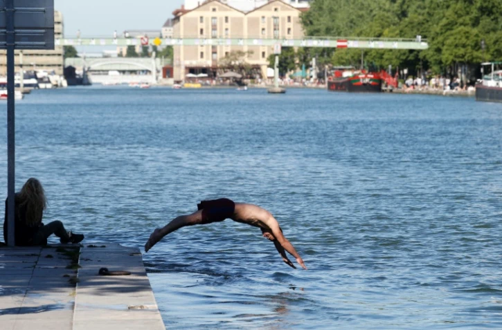 Un homme plonge dans les eaux du Bassin de la Villette à Paris le 26 mai 2017