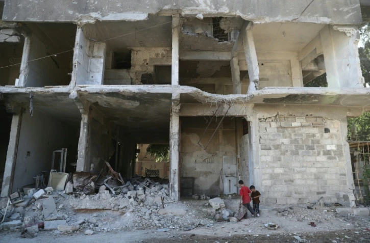 Des enfants dans les ruines d'un immeuble le 14 septembre 2016 à Hamouria à la périphérie de  les environs de Damas  
