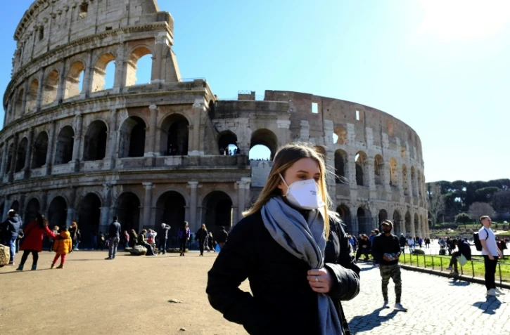 Des touristes portant des masques de protection devant le Colisée, à Rome le 28 février 2020. 