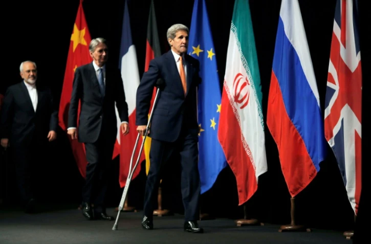 Le secrétaire d'Etat américain John Kerry (d), le ministre britannique des Affaires étrangères Philip Hammond (c) et son homologue iranien Mohammad Javad Zarif (g), après la signature d'un accord sur le nucléaire iranien, le 14 juillet 2015 à Vienne