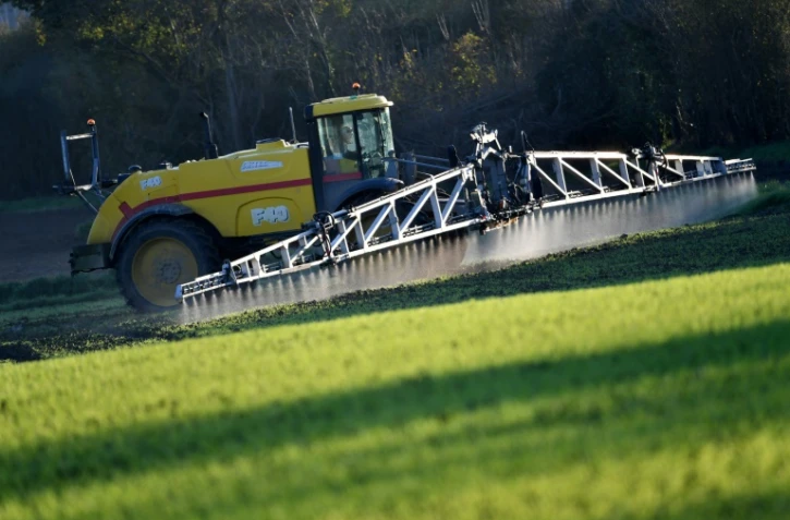 Un agriculteur avec un pulvérisateur de 36 mètres de large répand du "Lambdatine", un insecticide racinaire mélangé avec du"Foburi", un herbicide, près d'Illiers-Combray, dans le centre de la France, le 14 novembre 2024