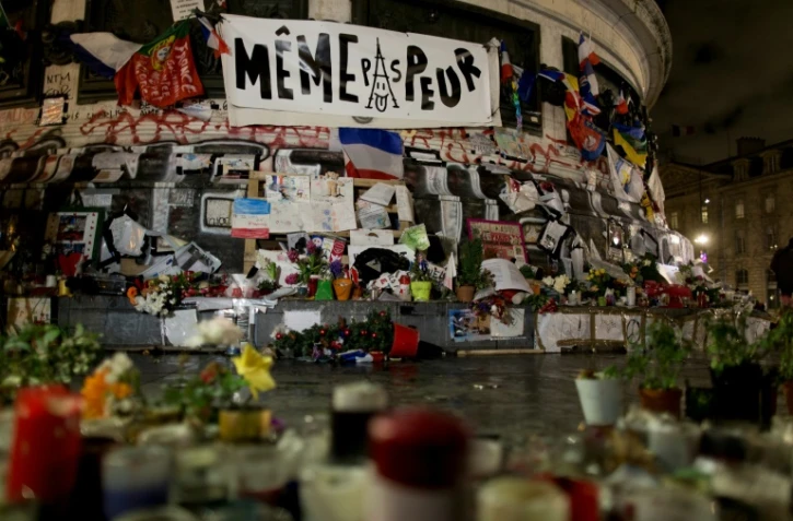 Des messages et des bannières déposées sur la place de la République à Paris le 7 janvier 2016, en hommage aux victimes des attentats de janvier 2015