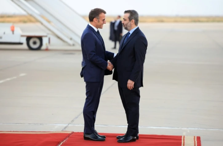 Le président français Emmanuel Macron est accueilli par le ministre syrien des Affaires étrangères Asaad al-Shaibani, le 6 juillet 2026 à l'aéroport de Damas