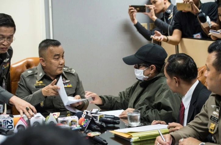 La mère d'une victime de trafic sexuel (3ème D) parle à un policier lors d'une enquête au bureau du siège de la police à Bangkok, le 25 avril 2017