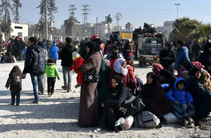 Des civils en attente à un point de contrôle tenu par les forces du régime le 10 décembre 2016 à al-Hawoz un quartie d'Alep est