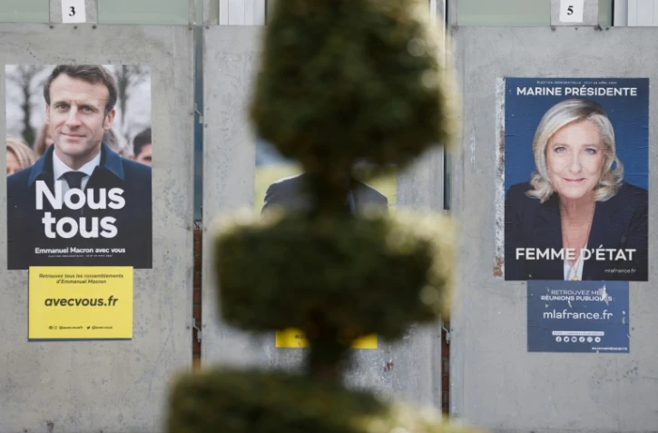 Une photo prise à Denain, le 11 avril 2022, montre des affiches de campagne des candidats à la présidence française, le président sortant Emmanuel Macron et la candidate du Rassemblement national (RN) Marine Le Pen
