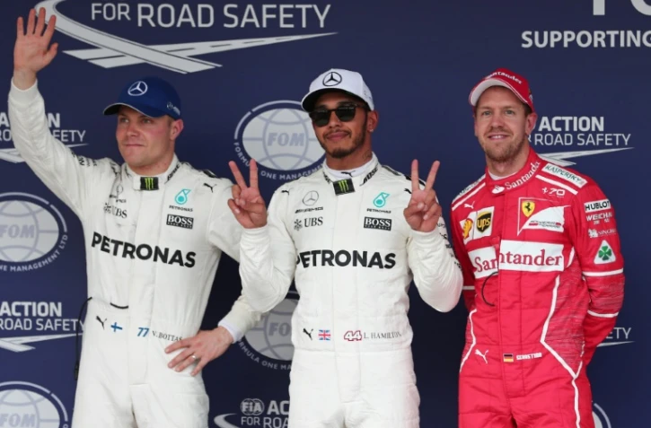 Le Britannique Lewis Hamilton (c) pose sur le podium après avoir obtenu la pole position du GP du Japon au volant de sa Mercedes, le 7 octobre 2017 à Suzuka