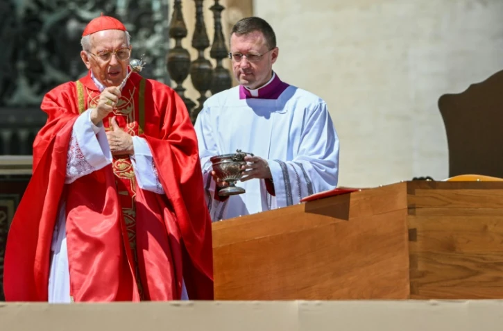 Le cardinal italien Giovanni Battista Re bénit le cercueil du pape François, sur lequel est posé le livre des évangiles, lors de la cérémonie funéraire place Saint-Pierre au Vatican, le 26 avril 2025