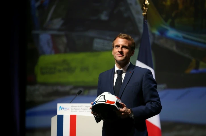 Le président français Emmanuel Macron un casque de pompier dans les mains lors du 127e congrès national des sapeurs-pompiers de France à Marseille, le 16 octobre 2021