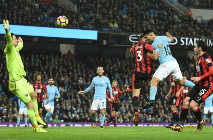 Sergio Aguero (d) de Manchester City fait une tête pour marquer le troisième but contre l'équipe de Bournemouth, le 23 décembre 2017 à Manchester City