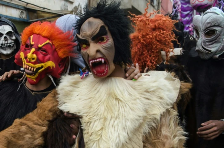 De jeunes marocains portant des masques d'horreur et des peaux animales célèbrent le festival de Boujloud dans la ville de Salé, le 27 octobre 2018