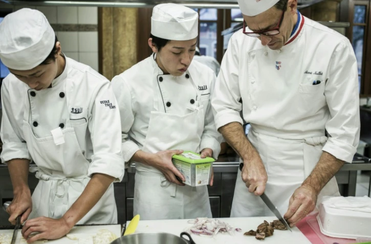 Un chef français (d) donne un cours de cuisine à des étudiants japonais à l'école Tsuji à Liergues, dans le Rhône, le 3 décembre 2015