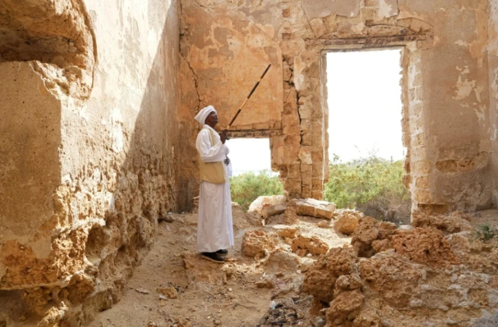 Un homme se tient debout dans une ruine à Suakin, au Soudan, le 22 janvier 2026 