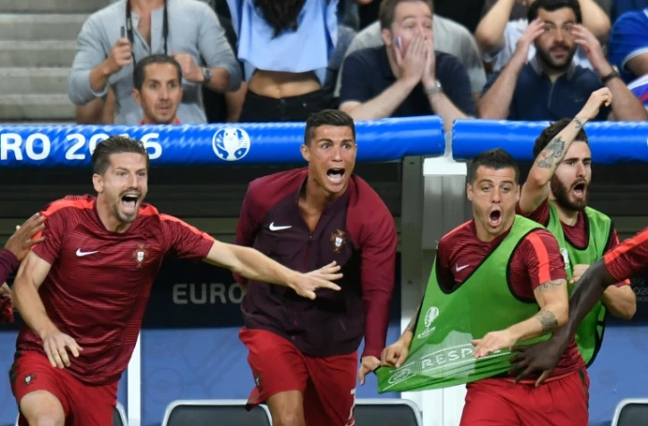 L'attaquant portugais Cristiano Ronaldo (c) exulte depuis le banc à l'issue de la finale de l'Euro, le 10 juillet 2016 au Stade de France
