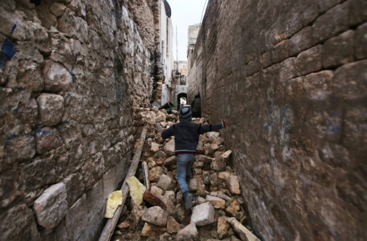 Un enfant se fraye un chemin à travers les ruines de bâtiments à Alep, le 17 décembre 2016.