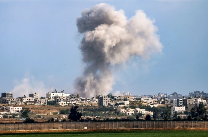 Un panache de fumée s'élève dans le ciel de la bande de Gaza, le 13 mai 2024, vu depuis Israël