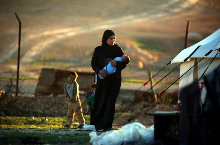 Une Syrienne tient son enfant dans ses bras,  dans un camp de réfugiés à Ain Issa, à 50 km de la ville de Raqa