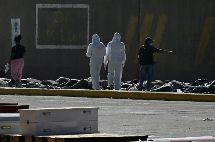 Des experts médicolégaux procèdent à l'identification de corps étendus au sol dans une morgue de fortune située dans le port de La Guaira, au Venezuela, le 29 juin 2026