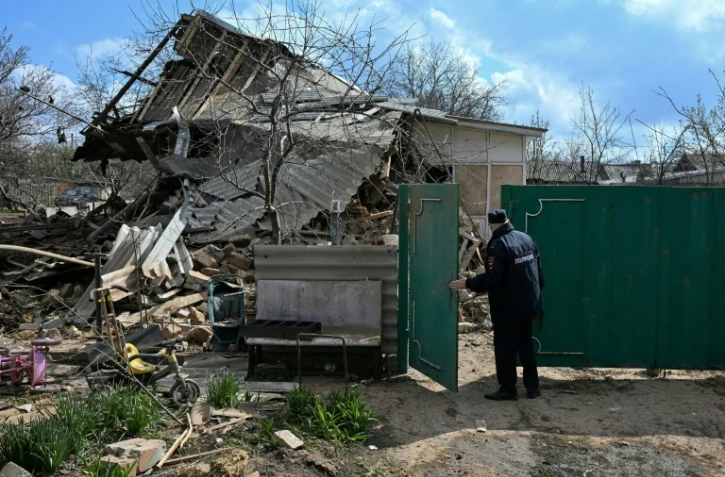 Un policier russe inspecte une maison détruite après une attaque aérienne à Yasynuvata, dans la région ukrainienne de Donetsk contrôlée par la Russie, le 11 avril 2026