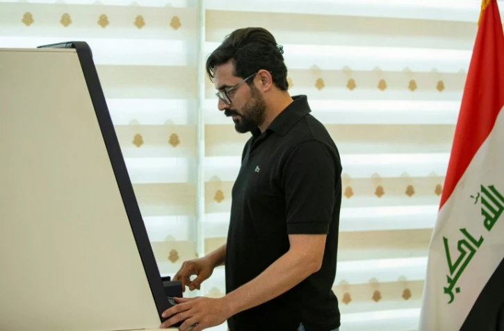 Al-Harith Hassan, employé du secteur pétrolier, retire de l'argent le 8 décembre 2023 à Bassora, la grande ville du sud de l'Irak