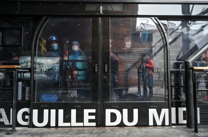 Des skieurs portent des masques de protection dans la cabine du téléphérique de l'Aiguille du Midi, le 16 mai 2020 à Chamonix