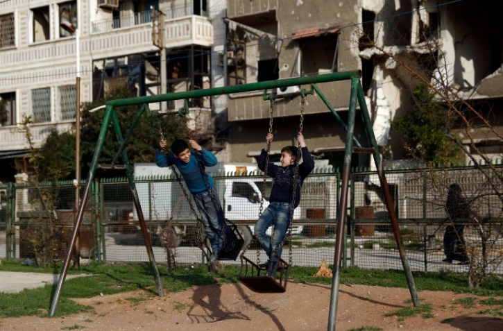 Des enfants sur une balançoire le 27 février 2016 à Douma au premier jour de la trève en Syrie