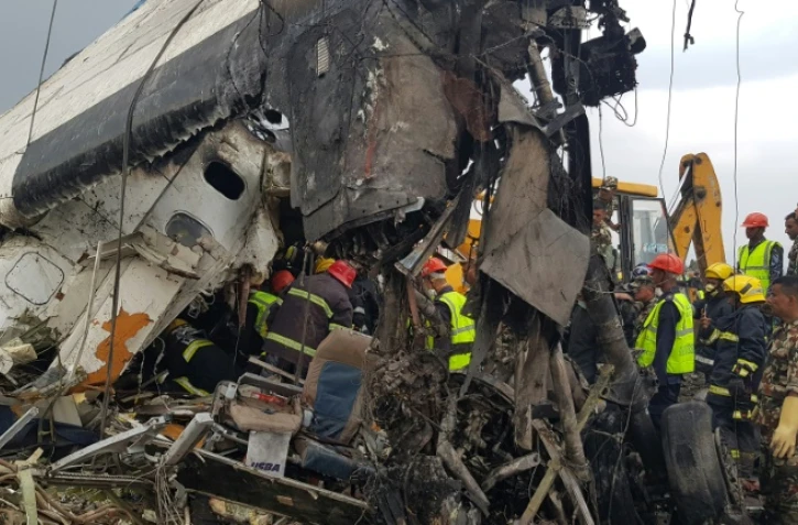 Des équipes de secours autour des débris d'un avion qui s'est écrasé près de l'aéroport de Katmandou, le 12 mars 2018 au Népal