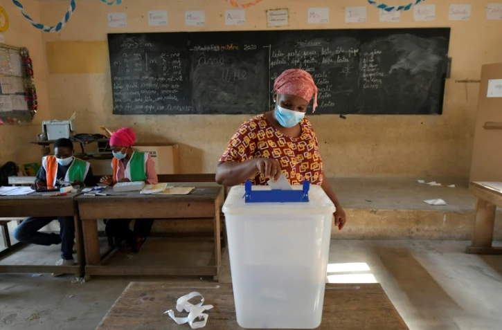 Une femme dépose son bulletin de vote à Abobo, le 31 octobre 2020, un quartier populaire d'Abidjan, lors de l'élection présidentielle en Côte d'Ivoire