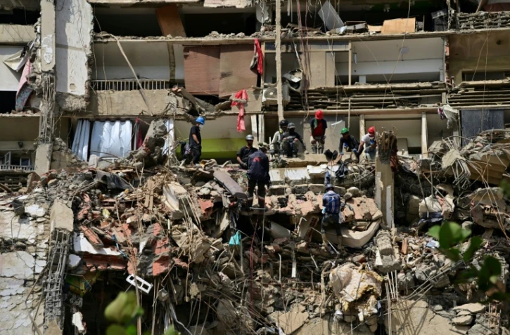 Des secouristes recherchent des victimes sur le site d'un immeuble effondré à Catia La Mar, dans l'État de La Guaira, le 6 juillet 2026 au Venezuela
