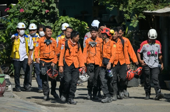 Des membres des équipes de secours quittent le site de l'effondrement de l'internat islamique Al Khoziny à Sidoarjo, dans l'est de Java, le 6 octobre 2025 en Indonésie