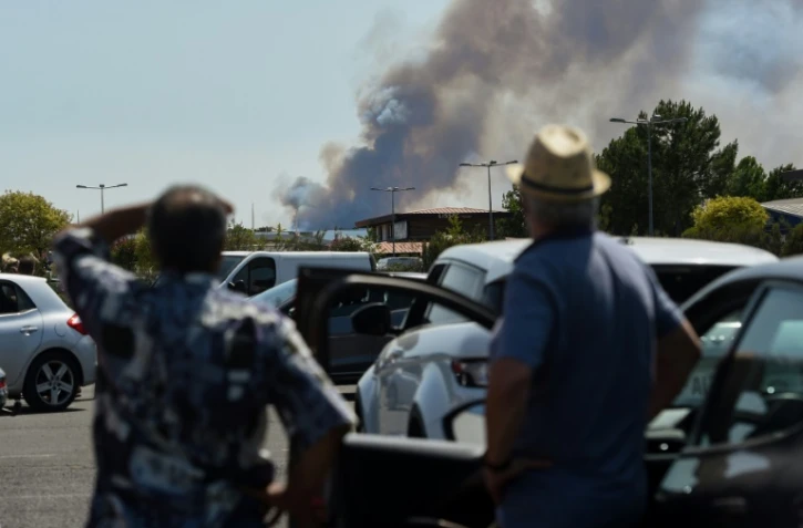 Des personnes observent l'incendie qui sévit près de La Teste-de-Buch, en Gironde, le 16 juillet 2022