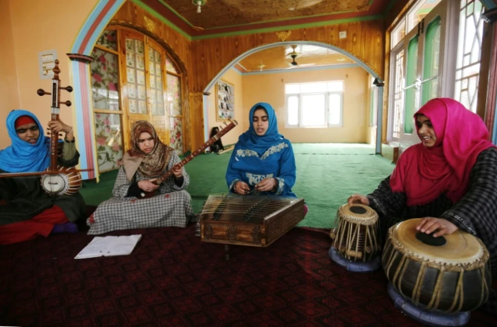 Des jeunes femmes soufies jouent de la musique traditionnelle sous l'oeil de leur professeur, le 25 février 2017 à Srinagar, au Cachemire indien