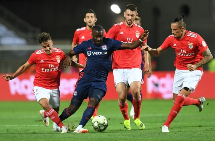 Le milieu de Lyon Tanguy Ndombélé (c) à la lutte avec le défenseur de Benfica Franco Cervi (g) en amical, le 1er août 2018 à Faro 