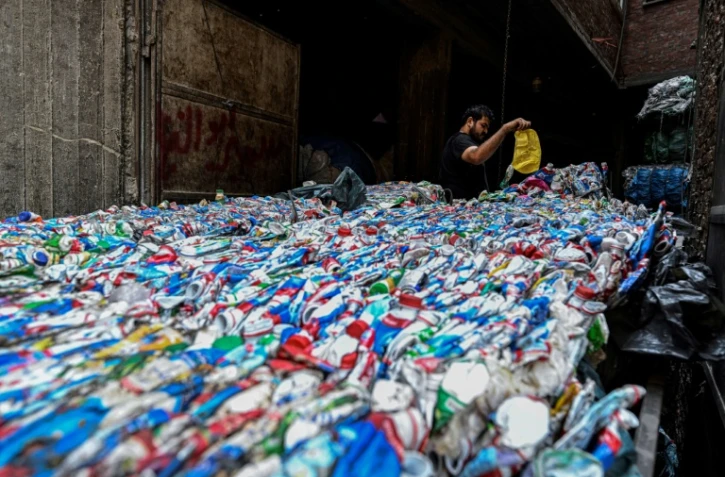 Un ouvrier égyptien conditionne du plastique destiné à être recyclé dans une usine de la "ville des déchets, dans le quartier de Manshiyet Nasser, au Caire le 6 juillet 2026