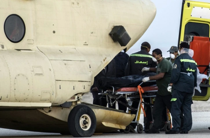 Des secouristes égyptiens sortent les corps des passagers de l'avion russe qui s'est écrasé dans le désert du Sinaï le 31 octobre 2015