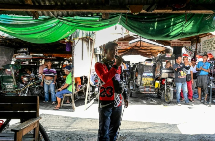 Un homme chante en karaoké dans une rue de Manille, le 17 octobre 2023 aux Philippines