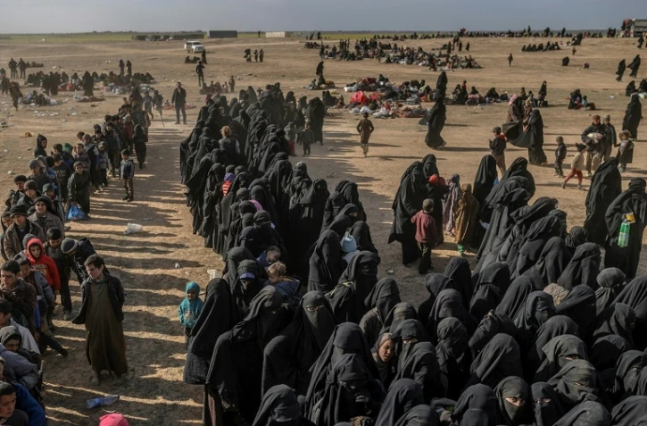 Des personnes attendent d'être fouillés par les Forces démocratiques 
syriennes après avoir quitté le dernier réduit du groupe Etat islamique, à Baghouz, dans l'est de la Syrie, le 5 mars 2019