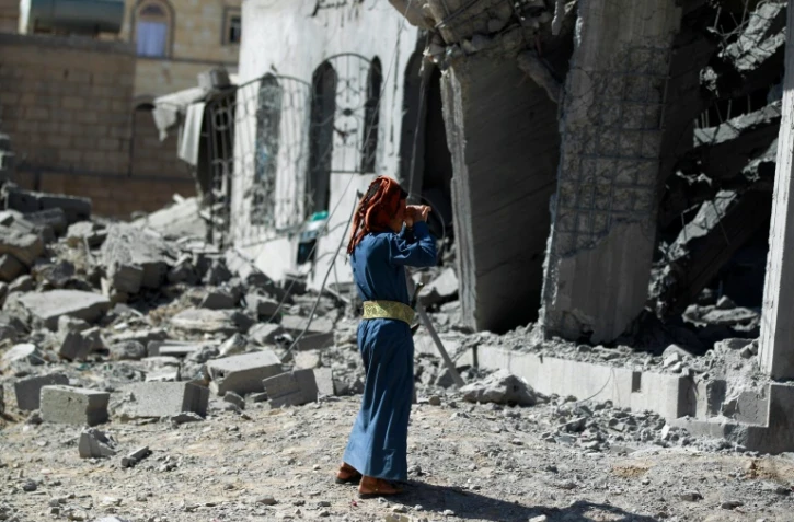 Un homme se tient devant un immeuble détruit par un bombardement de la coalition menée par l'Arabie saoudite, à Sanaa le 28 octobre 2015