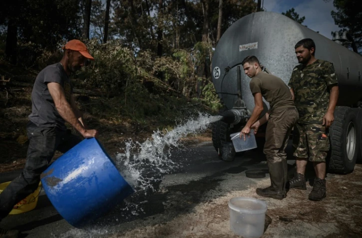 Des chasseurs installent des points d'eau pour abreuver les animaux après les incendies qui ont ravagé la zone, le 23 juillet à Pyla-sur-Mer (Gironde) 