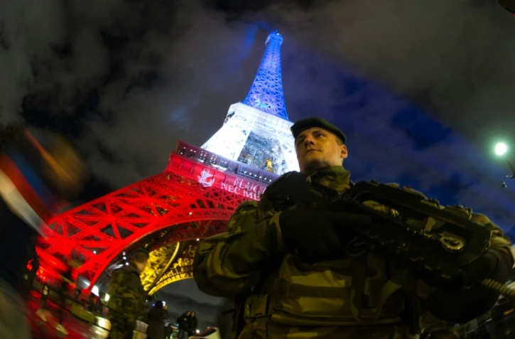 Un militaire du plan Vigipirate devant la Tour Eiffel le 16 novembre 2015 à Paris