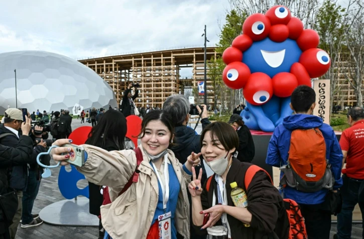 Des visiteurs prennent des sefies devant "Myaku-Myaku", mascotte de l'Exposition universelle d'Osaka au Japon, le 13 avril 2025