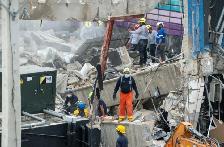Des équpes de secours sur le site de l'effondrement du toit d'une discothèque à Saint-Domingue, le 9 avril 2025 en République dominicaine