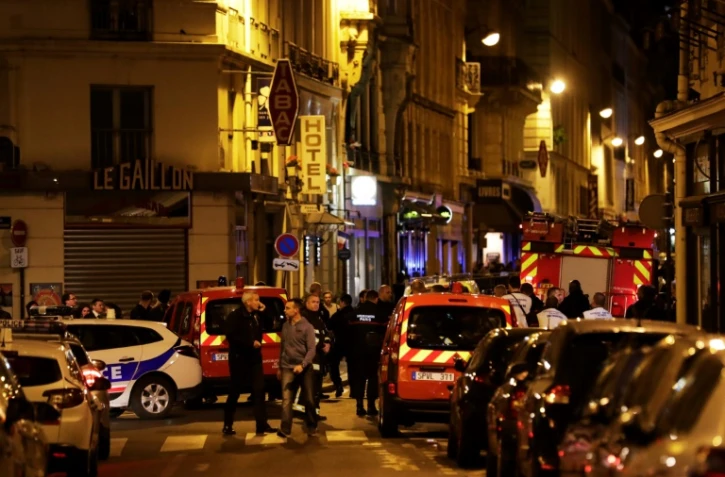 Les policiers et les sapeurs pompiers dans une rue bloquée après l'attaque au couteau qui a fait un mort, dont l'assaillant, et plusieurs blessés, à Paris le 12 mai 2018