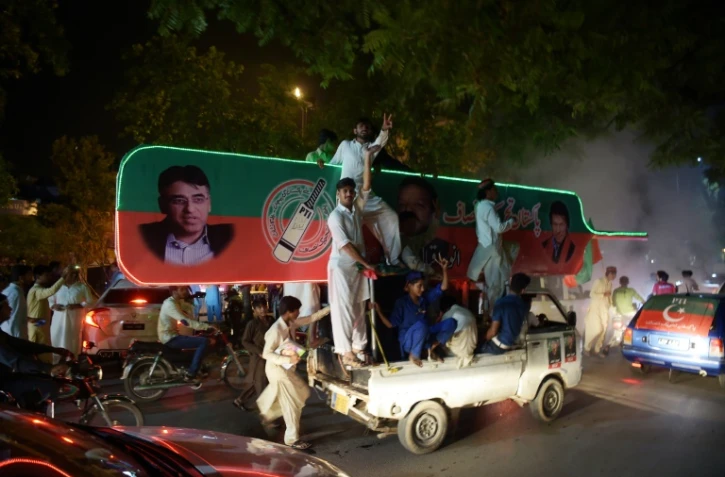 Des partisans de l'ancien champion de cricket Imran Khan, chef du Pakistan Tehreek-e-Insaf (PTI) manifestent leur joie dans une rue d'Islamabad le 25 juillet 2018