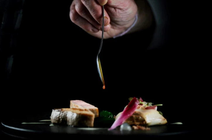 Un chef prépare un plat dans le restaurant "La Pyramide" à Vienne, en Isère, le 20 mars 2025