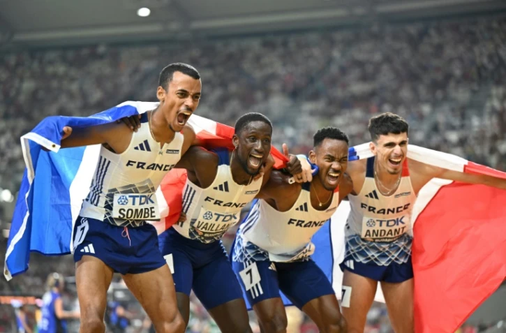 L'équipe de France de relais 4x400 m masculin (de gauche à droite) David Sombé, Ludvy Vaillant, Gilles Biron, and Téo Andant célèbre avec le drapeau français la médaille d'argent décrochée lors des Championnats du monde d'athlétisme à Budapest le 27 août 2023